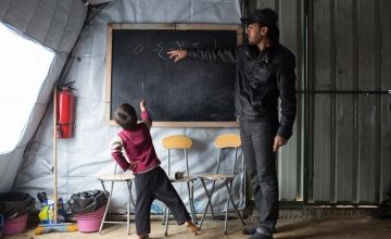 Syrian refugee boy studying in an informal classroom