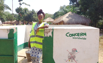 Marie Dabe, RECO RELSUDE, poses in front of the Siao water point in Kouango rehabilitated by Concern. Photo: Concern Worldwide.