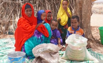 Amal Abdulahi with six children Rinwad (8), Khalid (7), Nimo (4), Jnale (5), Nahwo (3) and Hinda (10 months, out of shot) in Salahad, Legahida, Ethiopia, with food items she has purchased with cash transfer received through the ERNE programme. Photo: Conor O’Donovan / Concern Worldwide. 
