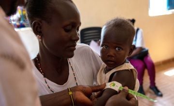 Concern staff members meet Everlyn Ekiru and her one-year-old Josephine at the local health clinic at Loiyangalani. Photo: Gavin Douglas/Concern Worldwide