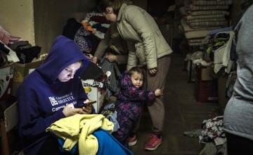 A young person looks through their phone in Lviv