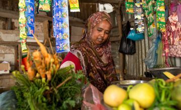 Saabirin* working at her grocery shop. Photo: Mustafa Saeed/Concern Worldwide