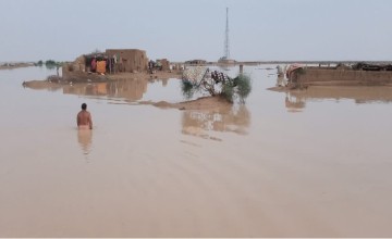 Villager trying to rescue in District Jhal Magsi, Pakistan. Whole village is submerged under muddied water and no rescue operation has been initiated yet. Photo by Concern