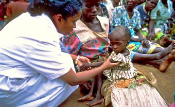 A nurse examines a malnourished child in Malawi in 2002
