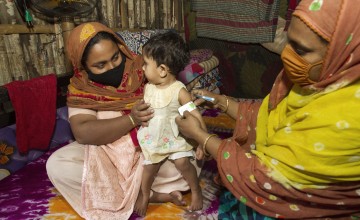 Concern’s Nutrition volunteer Shikha visits homes to provide nutrition support for children in urban slums. Jhumur Akter Moni (25) mother of Tasmia (14 months) pictured with Shikha. Photo: Emdadul Islam Bitu / Concern Worldwide