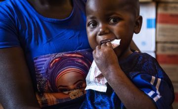Young baby eating from a packet of RUTF (ready-to-use therapeutic food) at a hospital in Central African Republic