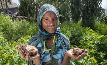 Ethiopian woman stands in her homestead garden