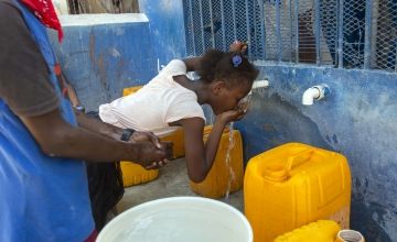 Girl in Cité Soleil, Haiti, drinking clean water out of a jerry can