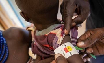 Child in Turkana, Kenya, has their mid-upper-arm circumference measured as a means of screening for malnutrition