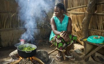 Central African woman cooking in her home