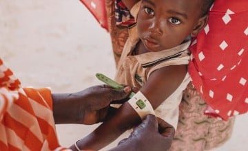 A child in Niger having their mid-upper arm circumference measured to screen for malnutrition