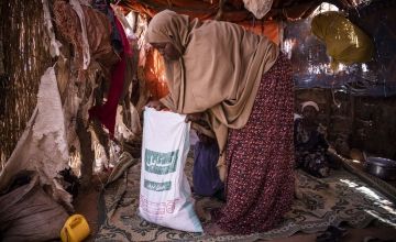Somali woman opening a bag of sugar