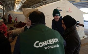 Concern staff delivering food to people in tents