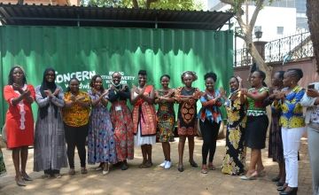 14 African women in a line crossing arms in front of them in 'X' pose
