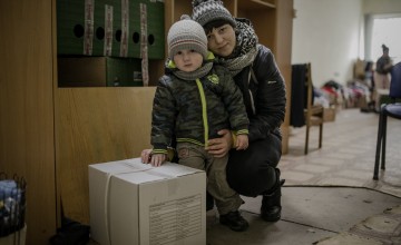 Darina* and her young son, Petro* with their food kit. Photo: Simona Supino/Concern Worldwide 