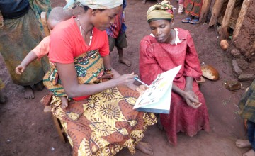 A maternal care group leader in Burundi talks with one of her group members