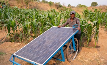Malawi farmer with solar powered irrigation pump that has enabled him to grow more food.
