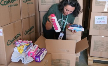 Concern's Ozge Celebi inspecting a box of baby supplies in a warehouse