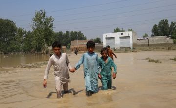 Children wade through floodwater in Pakistan