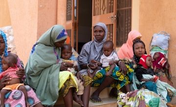 Mothers and their children sit outside recovery centre in Niger