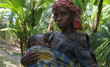 Woman holding her sleeping child in shawl in Burundi
