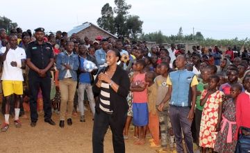Denise Dusabe, Vice Mayor of Social Affairs in Gisagara district, presents at an HIV/AIDS prevention and family planning event organized by Concern Rwanda. Five local teams participated in a soccer championship, with government representatives presenting both speeches and prizes. Local health center staff also offered voluntary HIV testing, distributed free condoms, and helped couples with selecting appropriate family planning methods.
