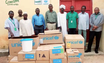 Concern staff standing with medical supplies