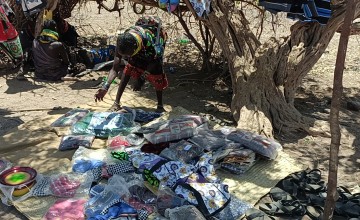 A woman works at her outdoor shop in Kenya