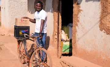 Jean de Dieu bought a bike to help transport goods to and from his grocery shop and now plans to buy a motorbike to make life easier.
