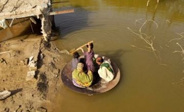 Aqib Aliin (14) transports people on his frying pan across the flooded waters in Jhuddo town of District Mirpurkhas of Sindh, Pakistan, in October 2022. The worst floods in decades impacted over 33 million people. Photo: Emmanuel Guddo/Concern Worldwide