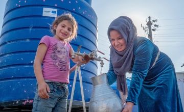 Darine* and her daughter show us the water tank in Turkiye