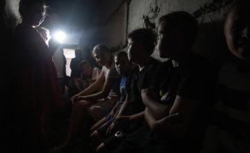 Children and teachers waiting in the dark, damp school bomb shelter for an air raid to end. Photo: Mykhaylo Palinchak/Concern Worldwide