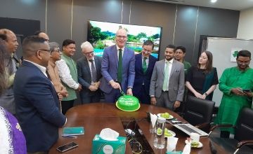 Minister Simon Coveney cutting St Patrick's Day cake at Concern Bangladesh office