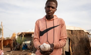 Younous holds up one of his pigeons at his shelter in a refugee camp in Eastern Chad. Photo: Eugene Ikua/Concern Worldwide