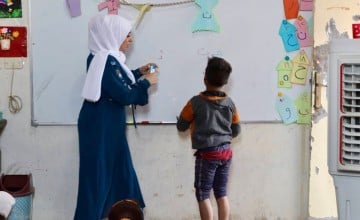 Hani (name changed) writing on blackboard in school