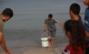 People collect sea water in southern Gaza, to use the water for cooking, cleaning and personal hygiene.
