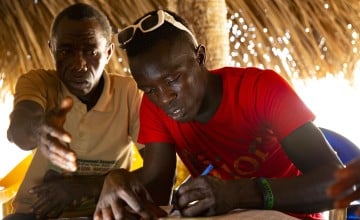 Yussuf Mansaray signs a document