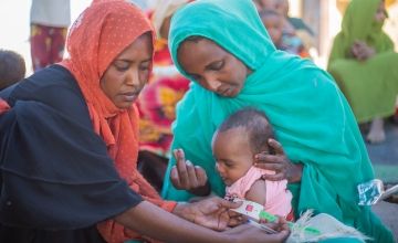 Two-year-old Aida is screened for malnutrition during the mass mid-upper arm circumference (MUAC) screening and referral for children under five in River Nile State. Aida is severely malnourished, very weak and requires immediate treatment. Photo: Ahmed Elfatih Mohamdeen/UNICEF