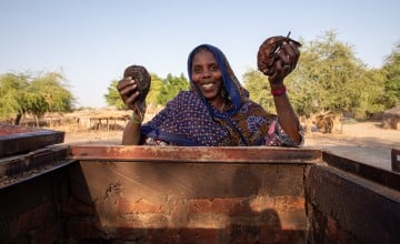 Aicha, President of Fishing Association, takes fish from the brick smoke house, constructed by Concern in Lac Province, Chad