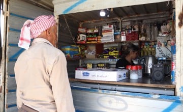 Safaa* serving man in her shop in northern Syria