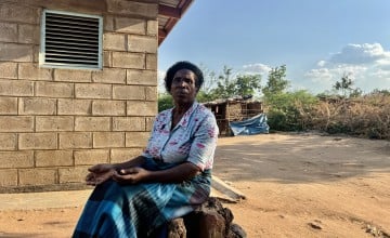 Sige, sitting in front of her home in Bitilinyu camp