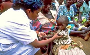 Nurse Sr Walsama checks a malnourished child in the Dowa region of Malawi in 2002 as part of Concern and Valid's CMAM program. (Photo: Pieternella Pieterse)