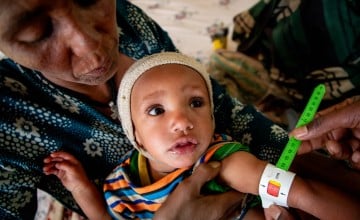 Azalu Tamu holds one of her twin girls as her mid-upper-arm circumference (MUAC) is measured in Amhara, Ethiopia. (Photo: Eugene Ikua/Concern Worldwide)