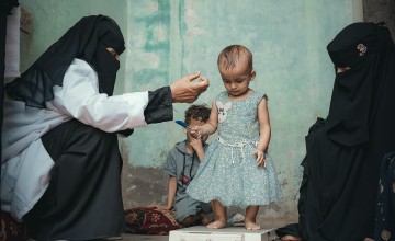 Rima* with her mother and Nabilah Mohammed, the Community Health Volunteer (CHV). Rima received treatment for malnutrition in a health center supported by Concern in Al-Shaqa’a village, Tuban district. Photo: Ammar Khalaf/Concern Worldwide