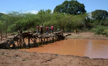 This river in Tana River County, Kenya, only fills up when there is rain, on any other day, it is a passage from one side of the community  to the other. This region however is prone to frequent flooding, washing the makeshift passage away. Photo: Shaloam Strooper/Concern Worldwide