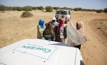 Concern's Nicola Brennan chats with staff members while the team adjust the straps on a load of supplies on their way to Um Shalaya health centre in Central Darfur