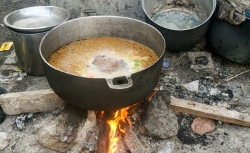 During the difficult weeks where Cité Soleil was on lockdown because of gang violence, each household had to be creative and find methods to cook food. This is a simple meal of rice and spices being prepared on some construction planks found close by. Photo: Comité Consultatif de Jeunes/Concern Worldwide