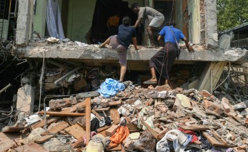 People climb into a damaged building as they look for survivors in Mandalay on March 29, 2025, a day after an earthquake struck central Myanmar. 