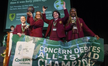 Four team members from Laurel Hill Secondary school stand on a stage with a banner in front of them, after receiving their awards for winning the Concern 2025 Debate final