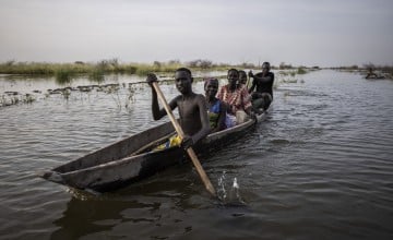 On a road that is now a river, people use a canoe to travel. Unity State, South Sudan. Photo: Ed Ram/Concern Worldwide